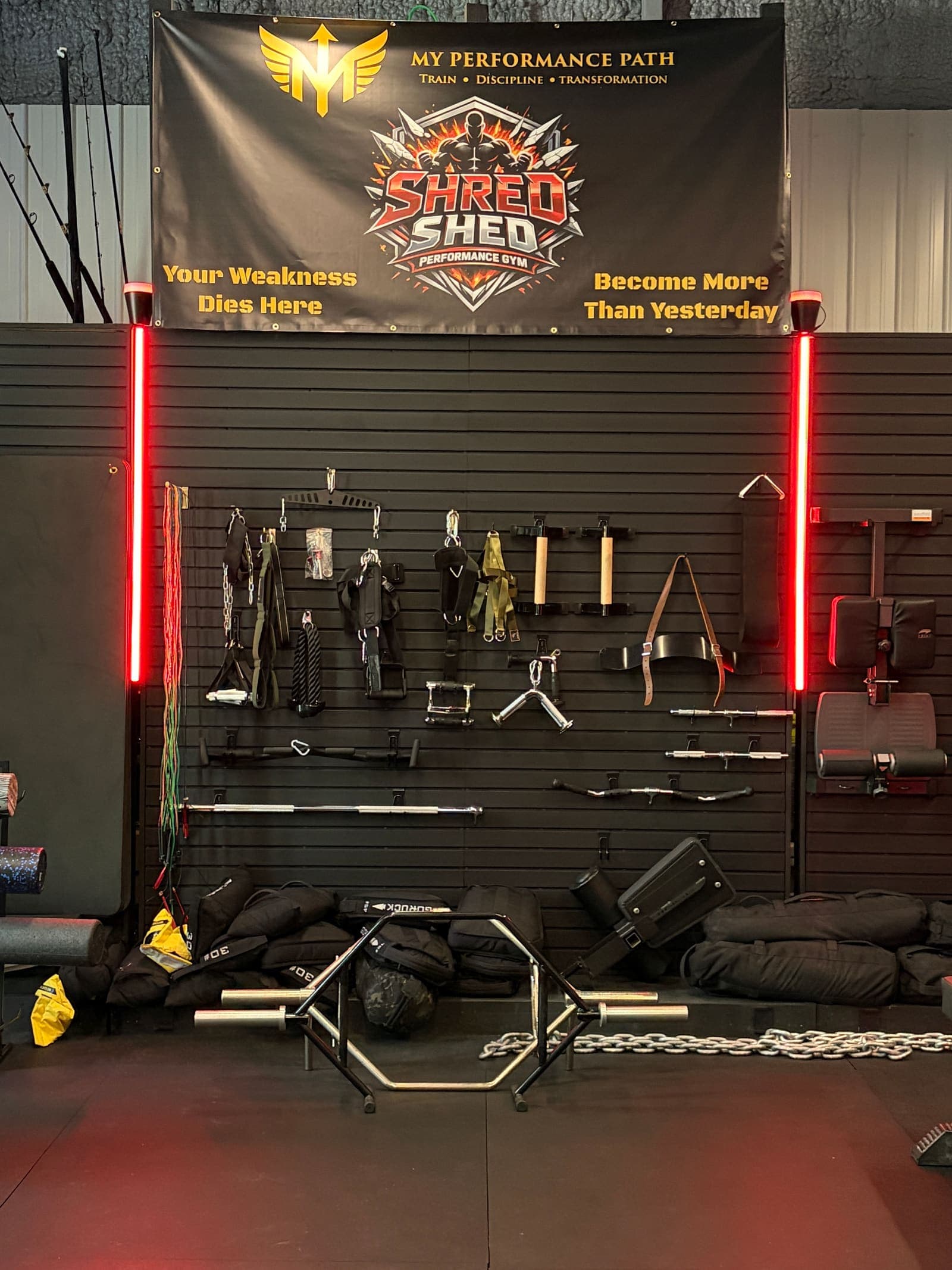 The Shred Shed gear wall — 'Your Weakness Dies Here. Become More Than Yesterday.'