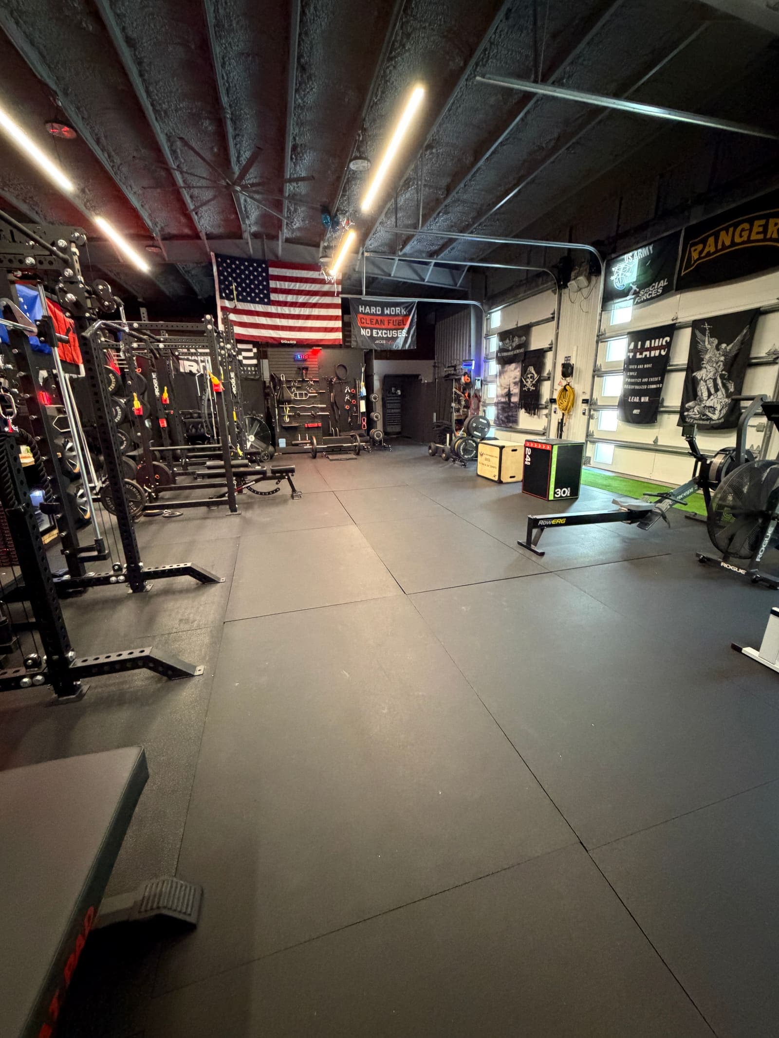 The Shred Shed strength floor — racks, rig, and flags